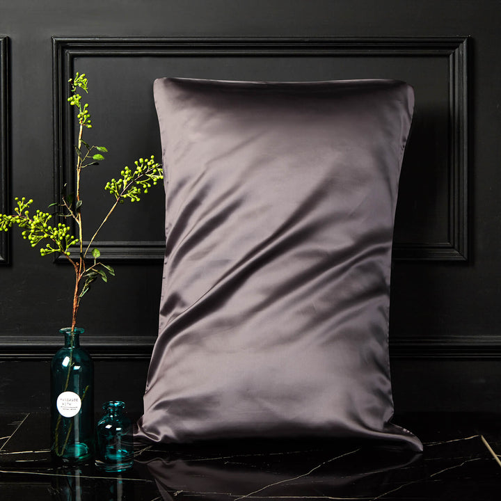 Dark gray silk pillowcase displayed upright against a dark background