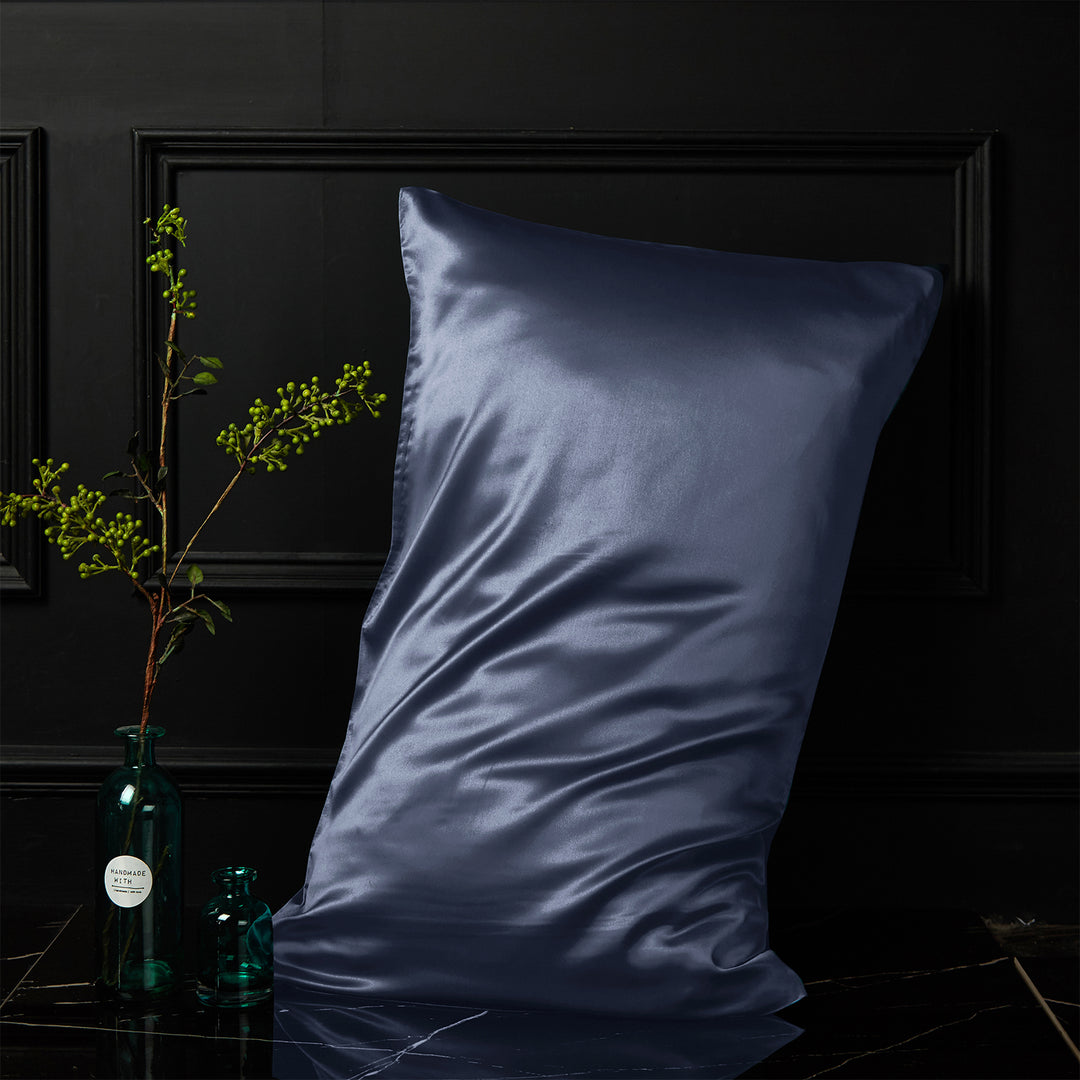 Navy silk pillowcase displayed upright against a dark background