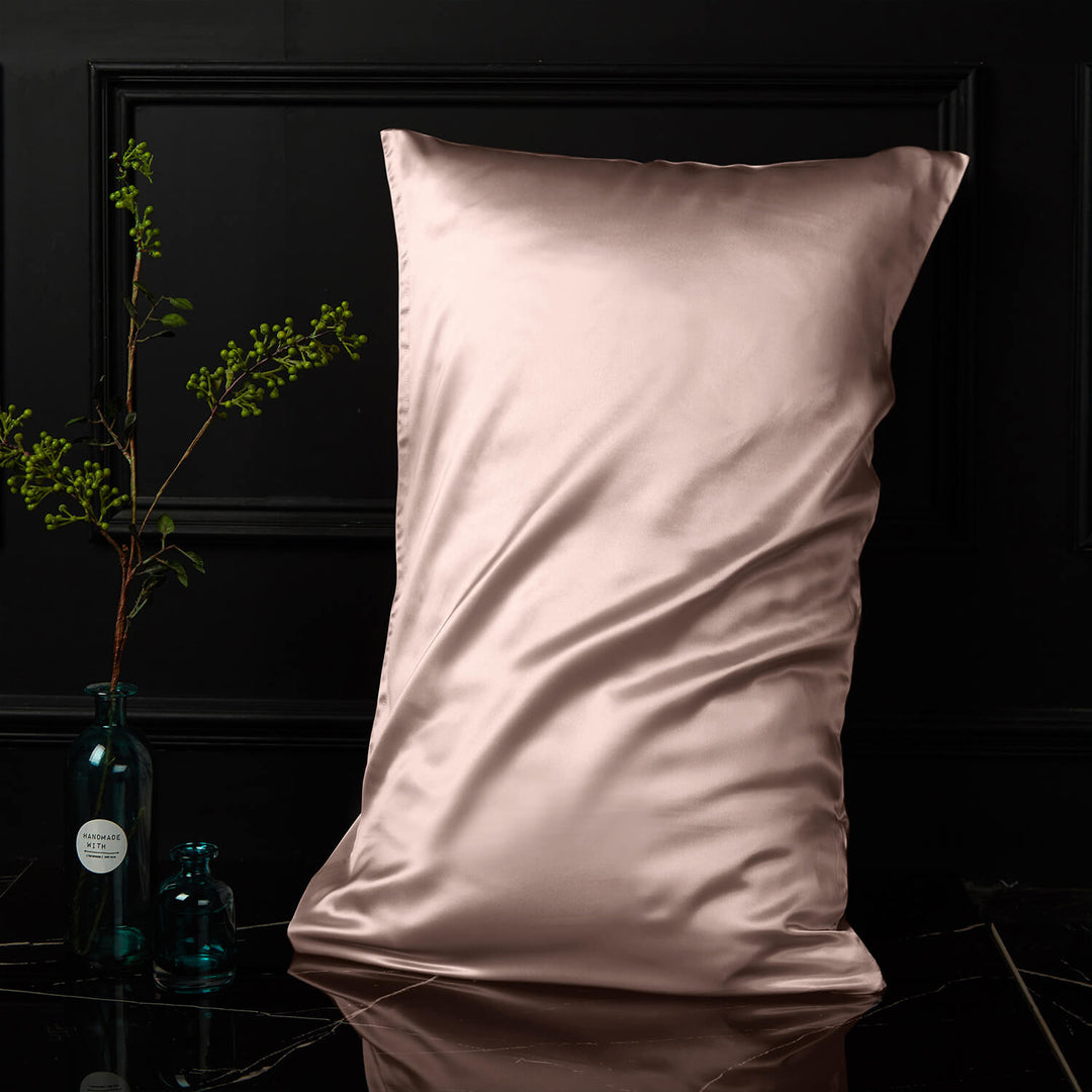 Champagne silk pillowcase displayed upright against a dark background