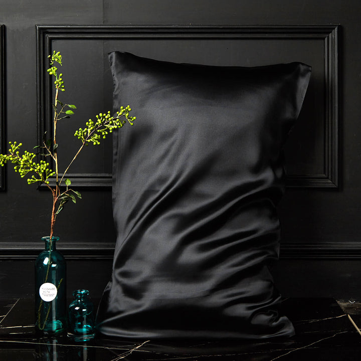 Black silk pillowcase displayed upright against a dark background