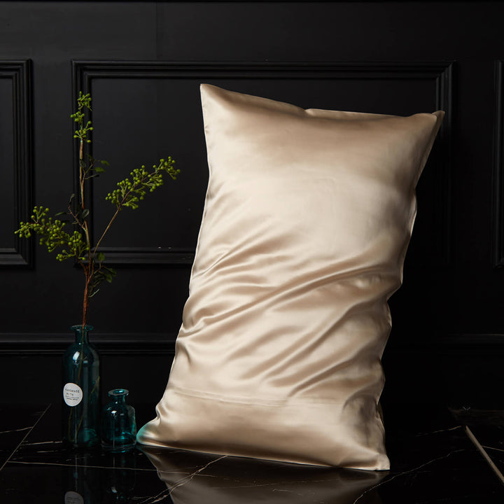 Gold silk pillowcase displayed upright against a dark background