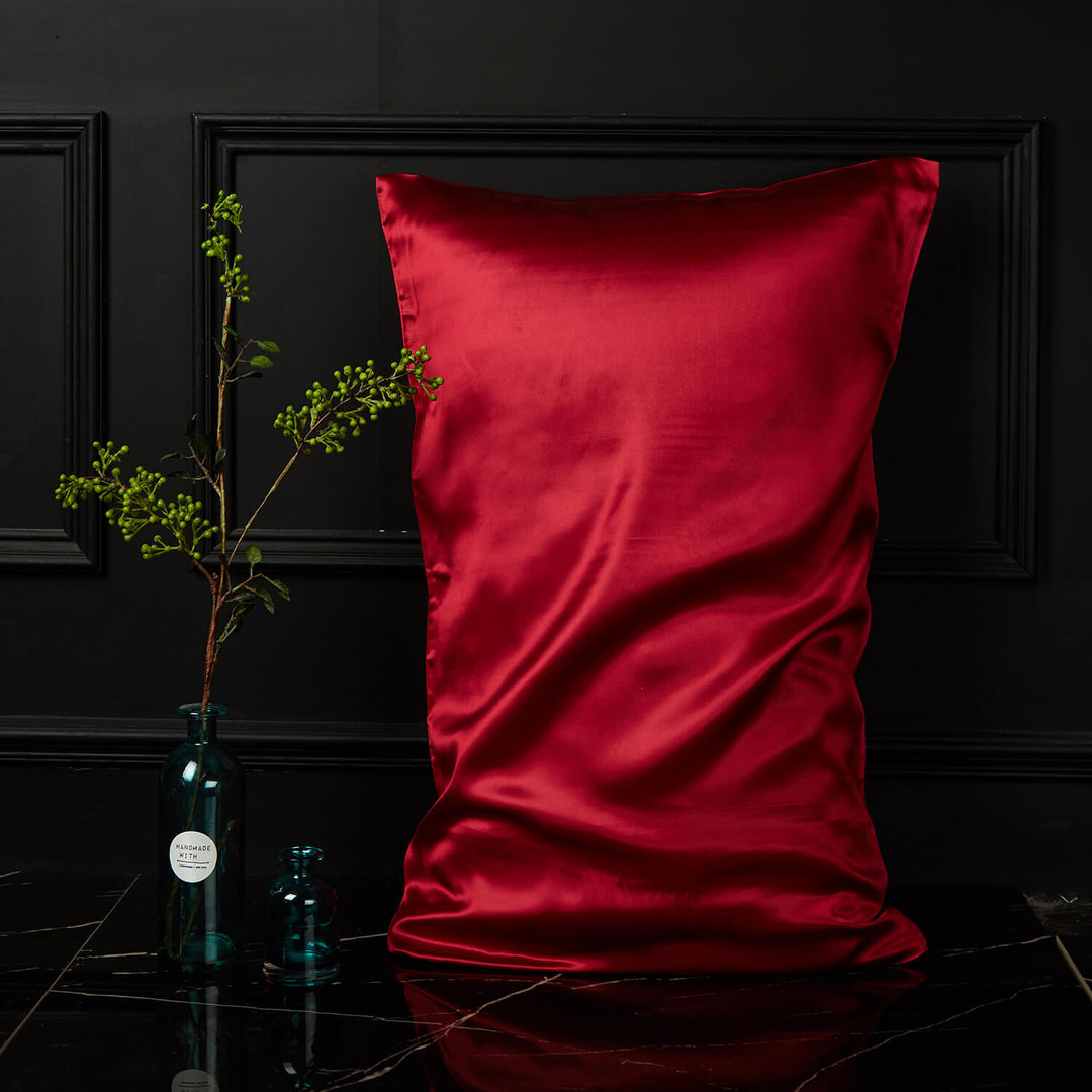 Red silk pillowcase displayed upright against a dark background