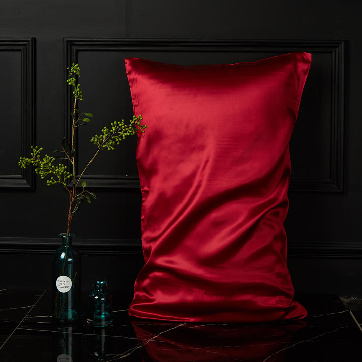 Red silk pillowcase displayed upright against a dark background