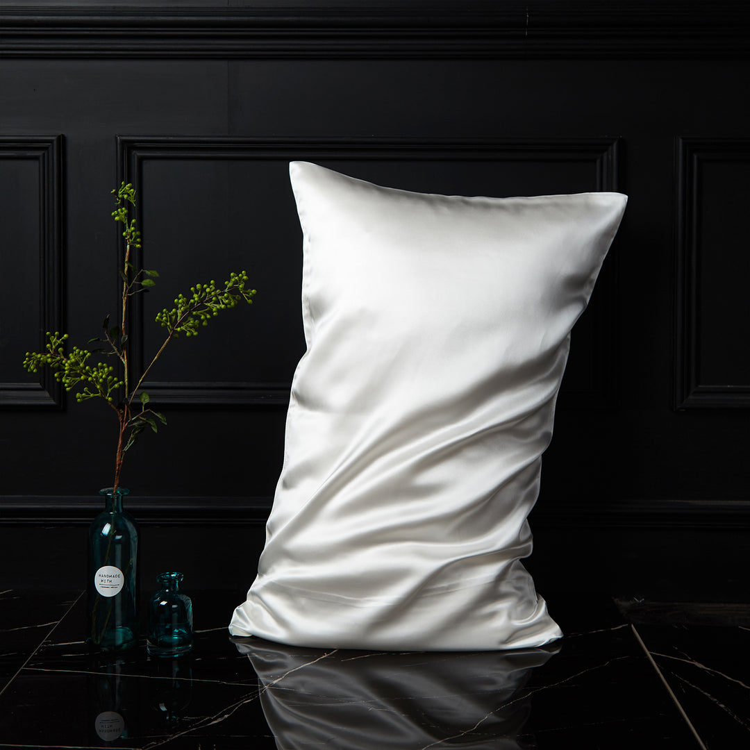 White silk pillowcase displayed upright against a dark background