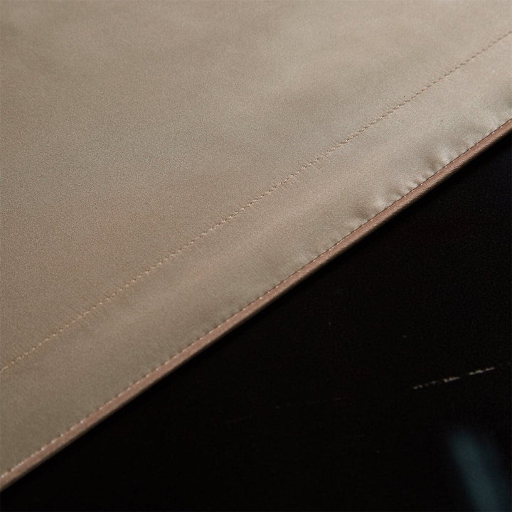 Close-up of stitching along a champagne pillowcase edge